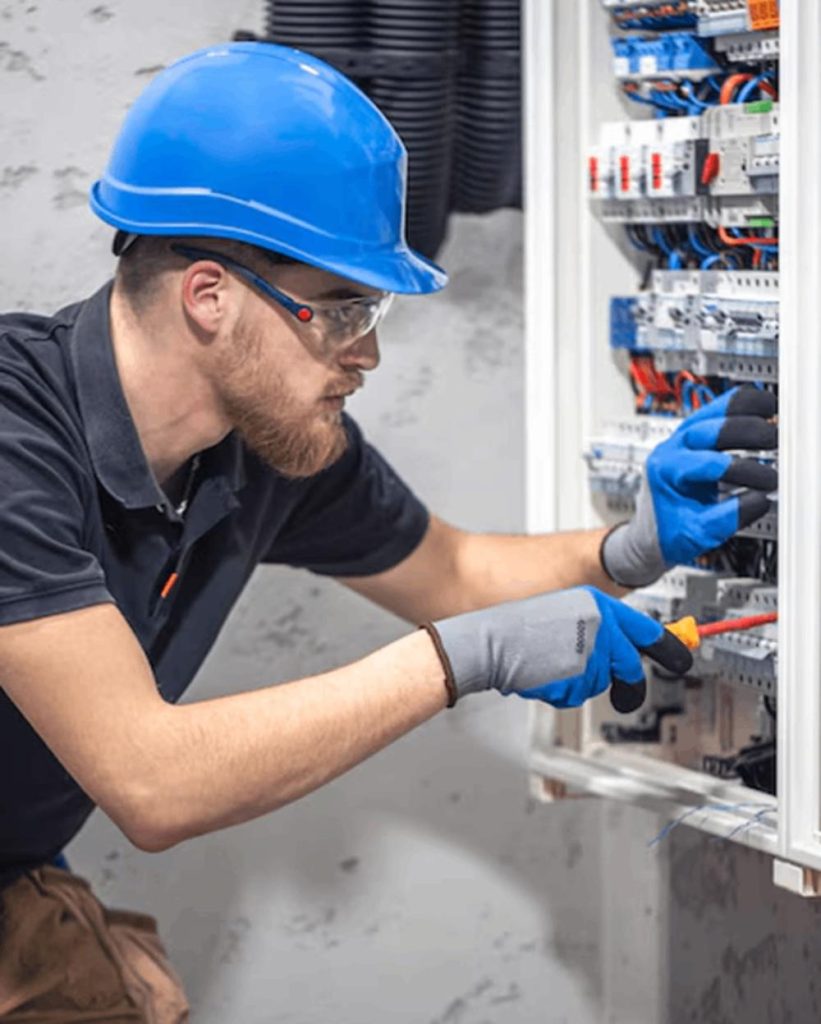 Mann bei Schaltkasten, Elektro Huber